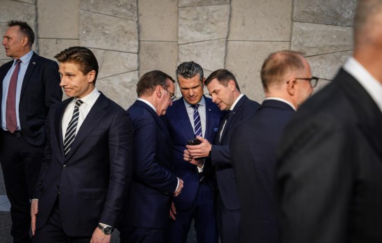 2025年10月15日,在比利时布鲁塞尔举行的北约防长会议结束后,美国国防部长赫格塞思(中)与欧洲国家官员交谈。新华社记者彭子洋摄